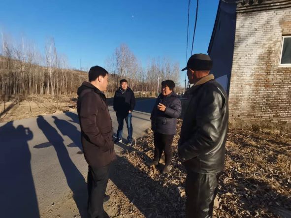 （图为赵辉对易县豹子峪村民有关洁净煤燃烧的问题进行详细解答）